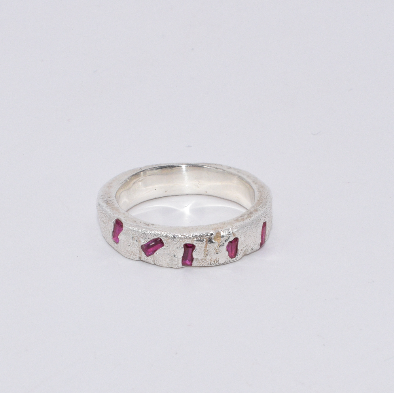 Naturally textured Sterling Silver band with 5 Ruby baguettes scattered across the front