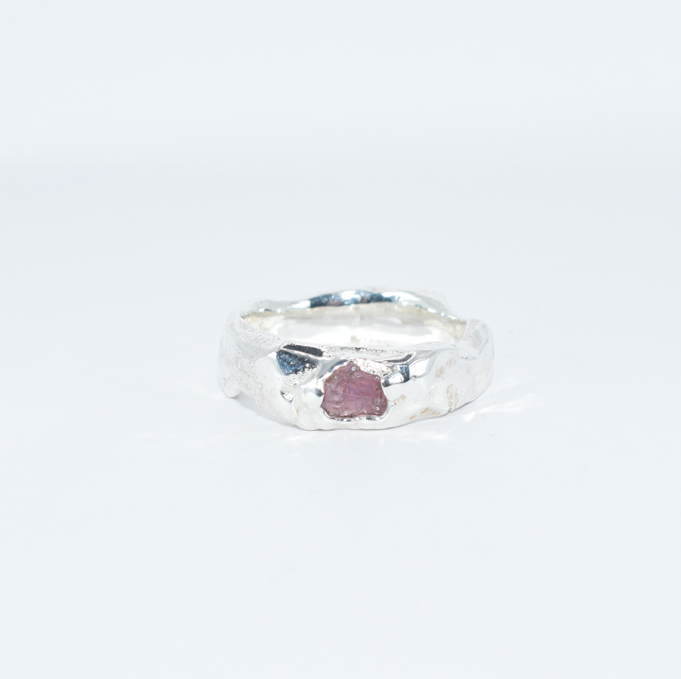 silver ring with raw pink sapphire set into front